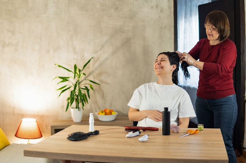 Femme Qui Se Fait Coiffer Chez Elle, Intérieur Table Avec Matériel De Coiffure Dessus, Lampe Et Plante