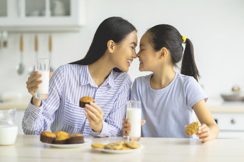 Mère Et Fille à Table Avec Gateaux Et Verre De Lait