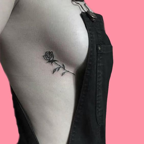 Tatouage rose discrète sur les côtes pour femme