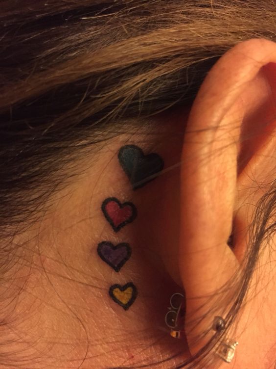 tatouage 4 cœurs colorés derriere l'oreille