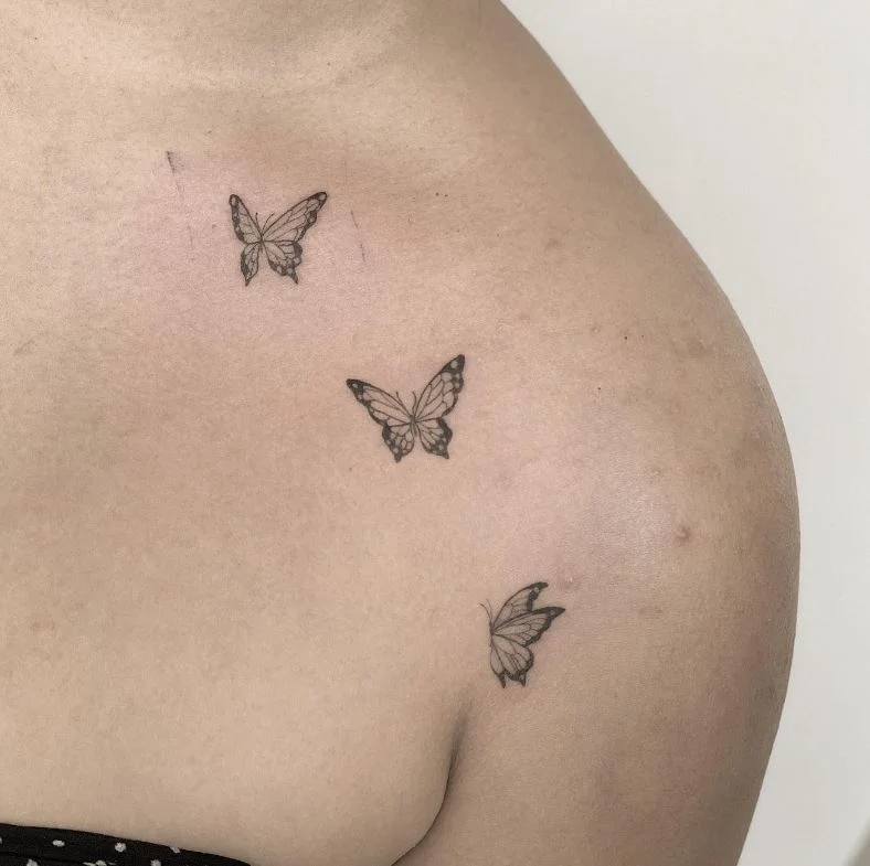 Trio De Papillon Sur La Clavicule