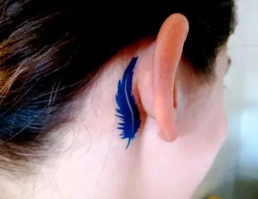 tatouage Plume bleu-marine derriere l'oreille
