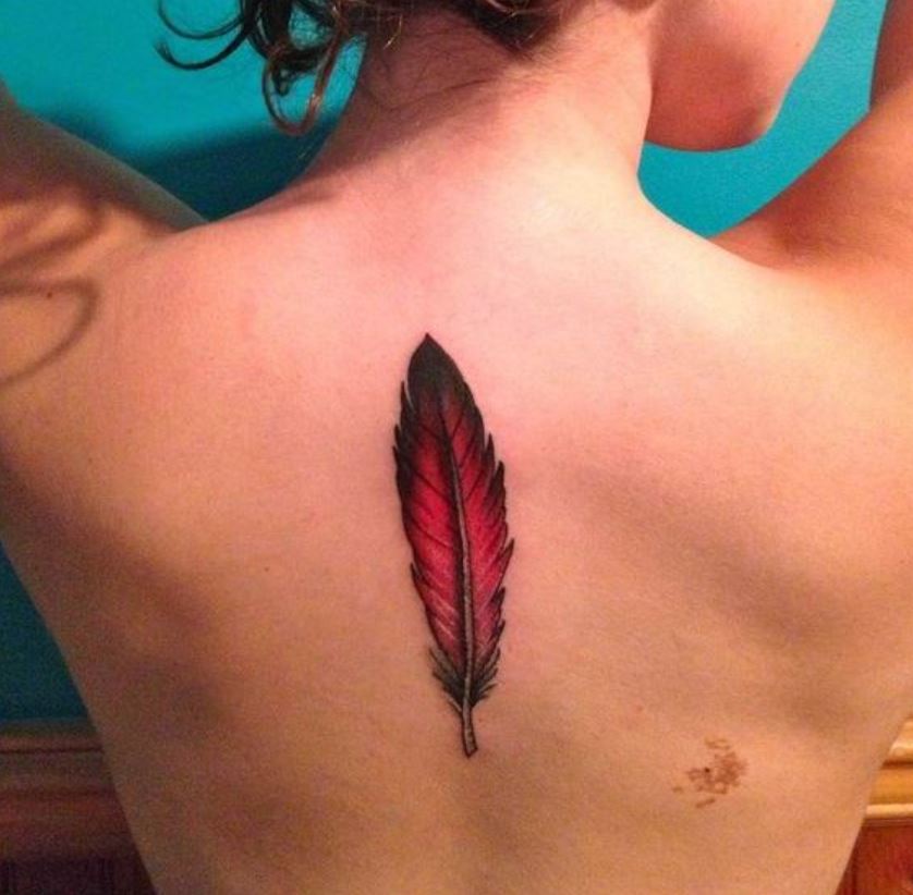 Tatouage Femme Plume Rouge Et Noir Sur Le Dos 