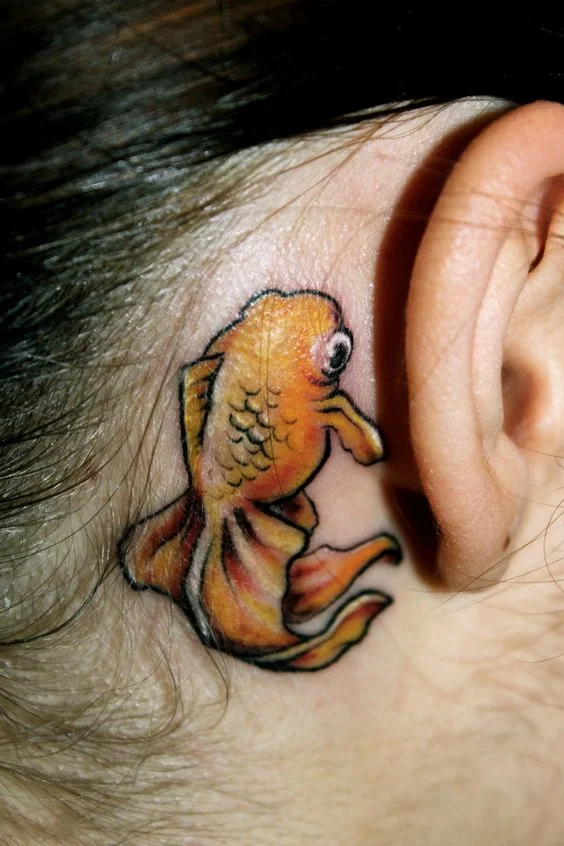 tatouage Poisson jaune derriere l'oreille