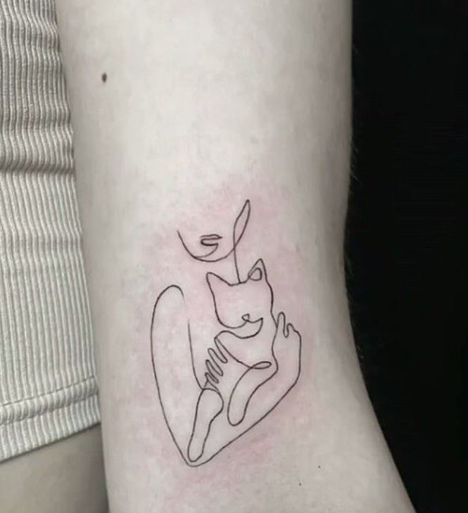 Tatouage Chat Minimaliste Dans Les Bras D'une Femme