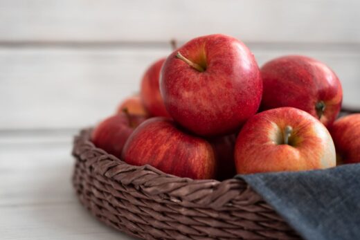 Pommes rouges fraîches dans un panier en osier.