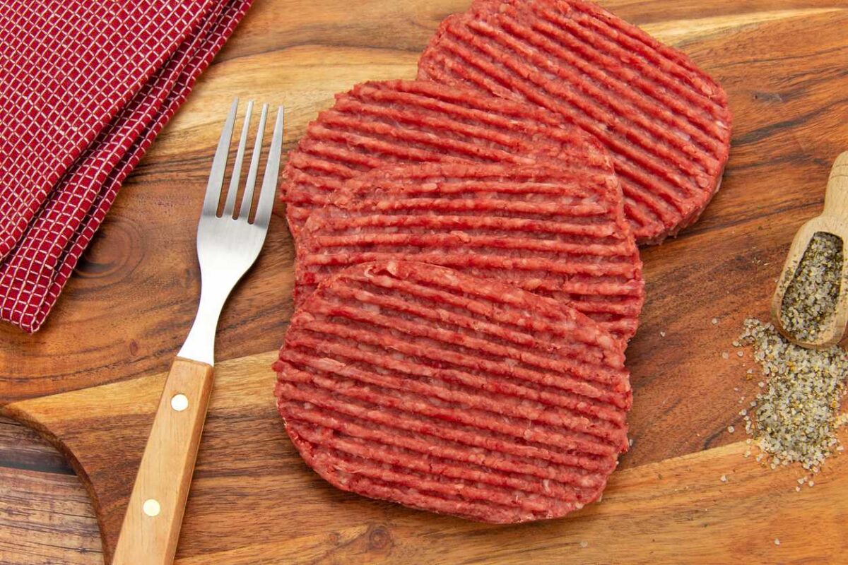 Steak haché cru sur table en bois et fourchette